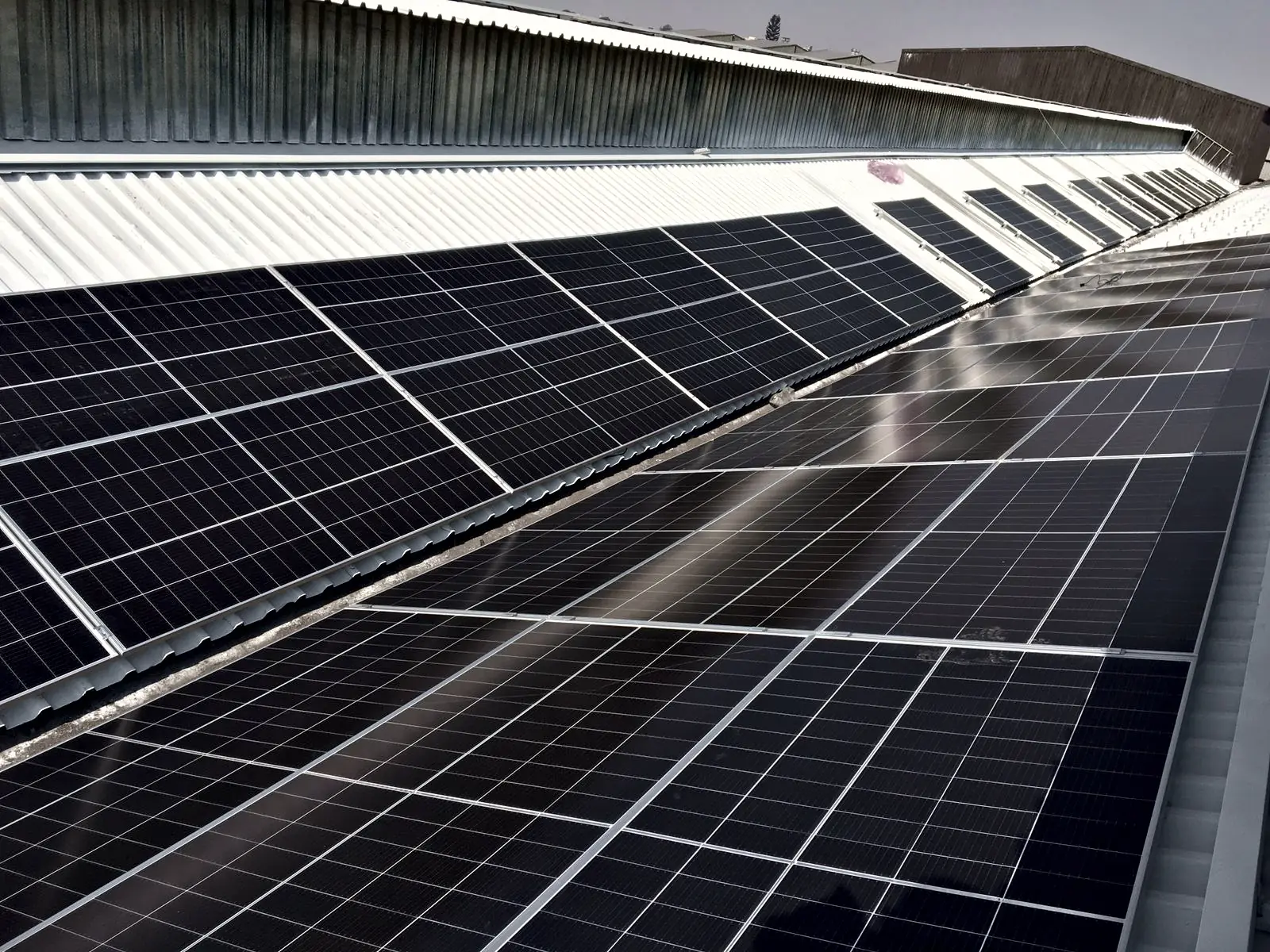 Rows of solar panels on a long industrial roof
